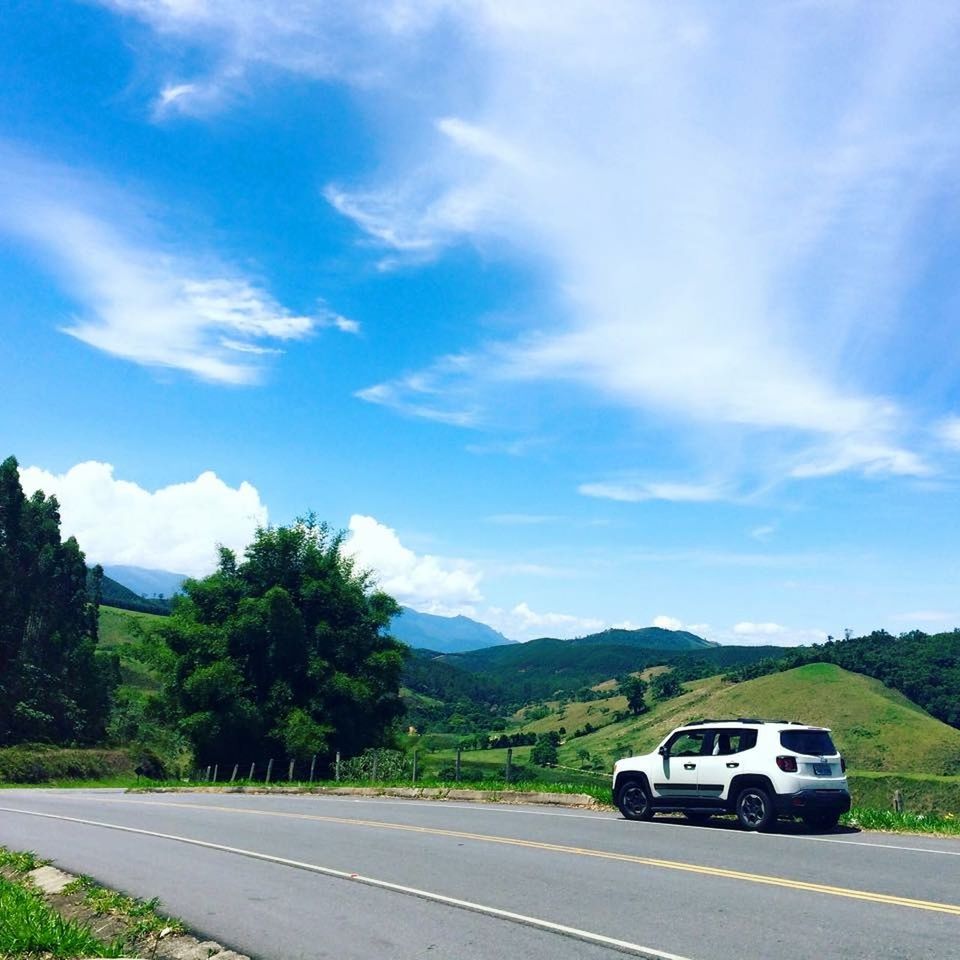 transportation, land vehicle, car, mode of transport, road, sky, mountain, landscape, cloud - sky, country road, cloud, travel, street, blue, on the move, tree, road marking, the way forward, nature, day