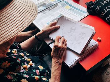 High angle view of woman reading book on table