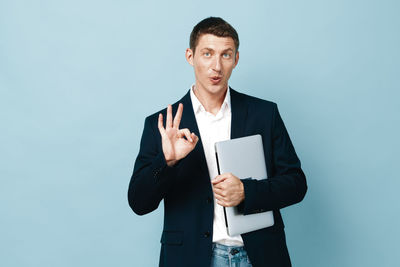 Young man using mobile phone against white background