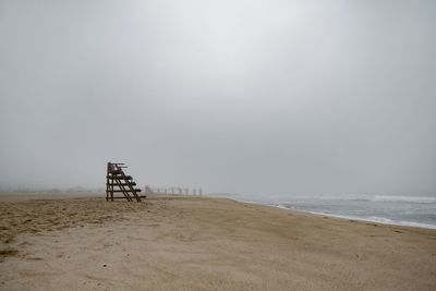 Lifeguard hut on beach against sky