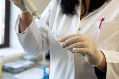 Midsection of scientist experimenting in laboratory