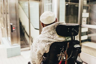 Rear view of disabled man on wheelchair at railroad station