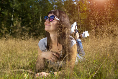 Beautiful young woman in sunglasses enjoys the sun on the grass person