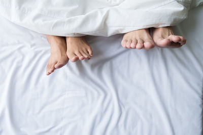 Low section of child sleeping on bed