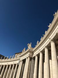 Low angle view of st peter basilica columns against clear blue sky