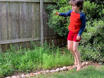 Full length of boy standing by plants