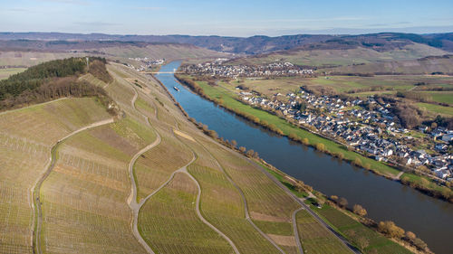 High angle view of river amidst field against sky