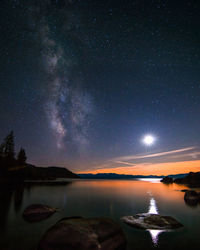 Idyllic view of moon glowing over lake at night