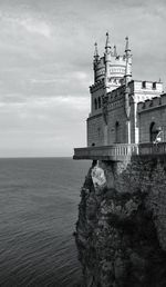 Lighthouse by sea against sky