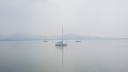 Sailboats in lake against sky