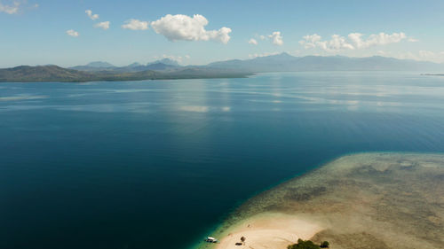 Honda bay with boats and sea with blue water and tropical islands covered with forest. 