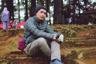 Portrait of young man sitting on field