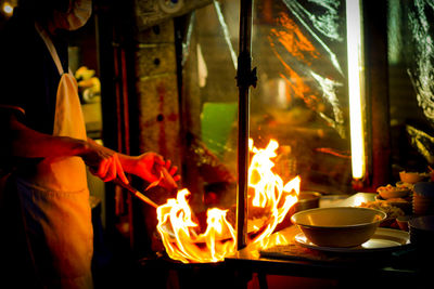 Midsection of man holding candles