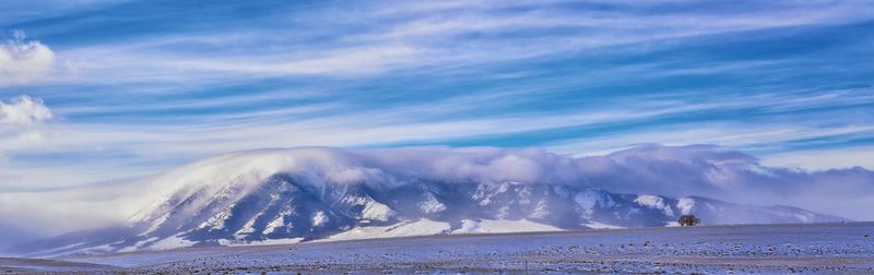 Scenic view of snowcapped mountains by sea against sky