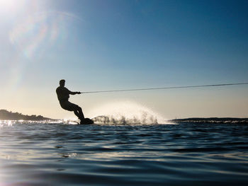 Silhouette man wakeboarding in sea