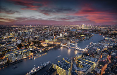 Aerial view of illuminated buildings against sky during sunset