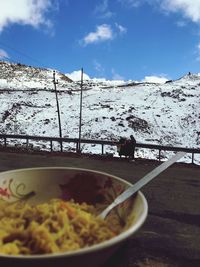 Close-up of food on table by sea against sky