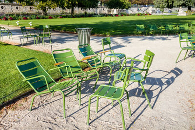 High angle view of empty chairs by swimming pool in park