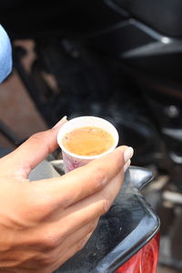 Midsection of man holding coffee cup