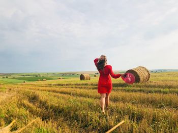 Rear view of woman on field against sky