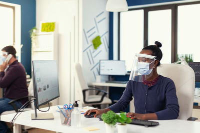 Rear view of man working in office