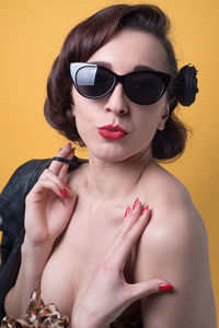 Portrait of sensual woman puckering against yellow background