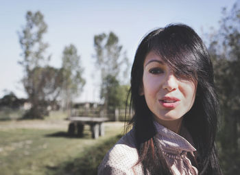 Portrait of beautiful woman against trees