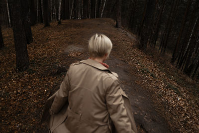 Rear view of woman walking in forest