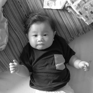 Close-up portrait of cute baby on bed