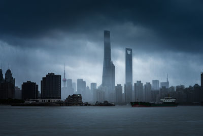 Modern buildings in city against cloudy sky