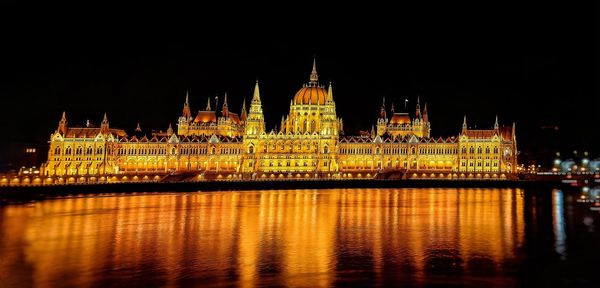 Illuminated city at waterfront during night