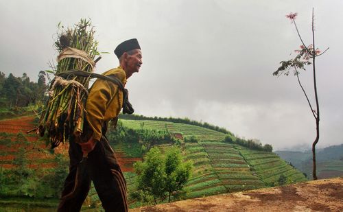 Man standing on field against sky