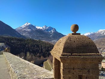 Rear view of snowcapped mountains against clear sky