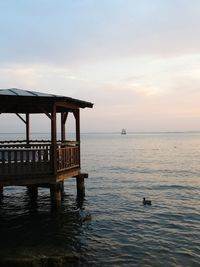 Pier over sea against sky during sunset