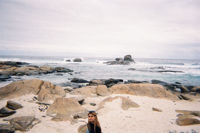 Woman at beach against sky