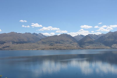 Scenic view of river and mountains against sky