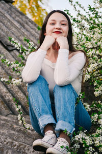 Low angle portrait of young woman sitting on roof