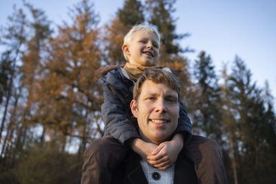 Happy man with son sitting on shoulders