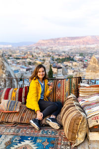 Woman is enjoying the glass of wine on the balcony at sunset