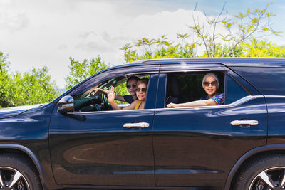 Three best friends enjoying traveling in the car on a road trip