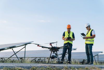 Men working at construction site against sky