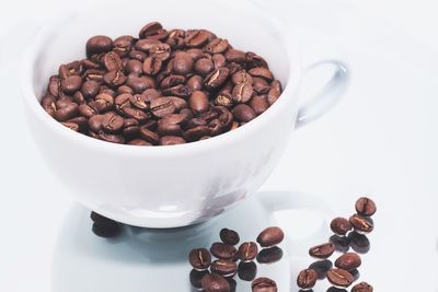 Close-up of coffee beans in cup on table