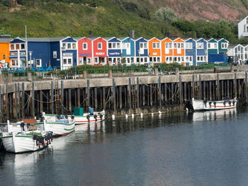 Sailboats moored on river by buildings in city