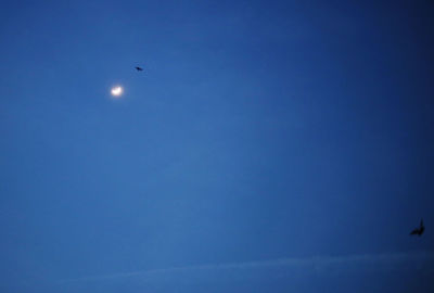 Low angle view of moon against blue sky