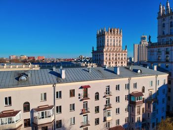 Buildings in city against clear blue sky