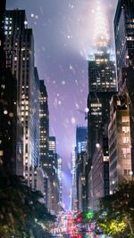 Illuminated buildings in city against sky at night