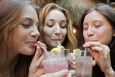 Happy young friends enjoying drinks at a bar