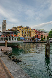 Bridge over river by buildings against sky