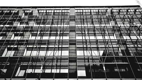 Low angle view of glass building against sky