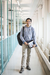 Portrait of young man standing in corridor of building